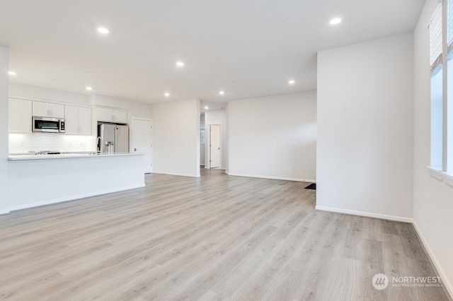 unfurnished living room with light wood-type flooring