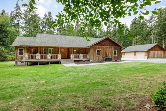 view of front facade with a garage, an outdoor structure, a front lawn, and a wooden deck