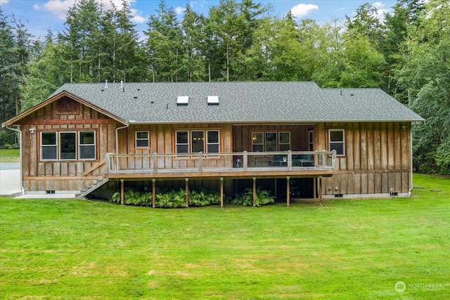 rear view of property with a yard and a deck