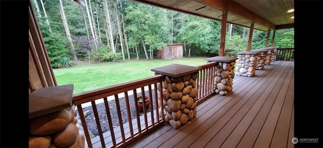 wooden terrace featuring a lawn