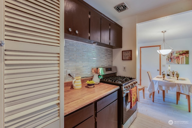 kitchen featuring dark brown cabinetry, stainless steel gas range, light hardwood / wood-style flooring, backsplash, and decorative light fixtures