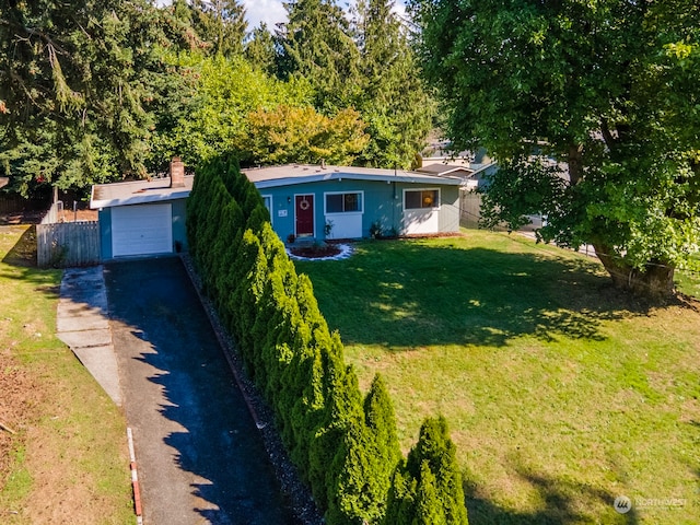 ranch-style house with a garage, an outbuilding, and a front lawn