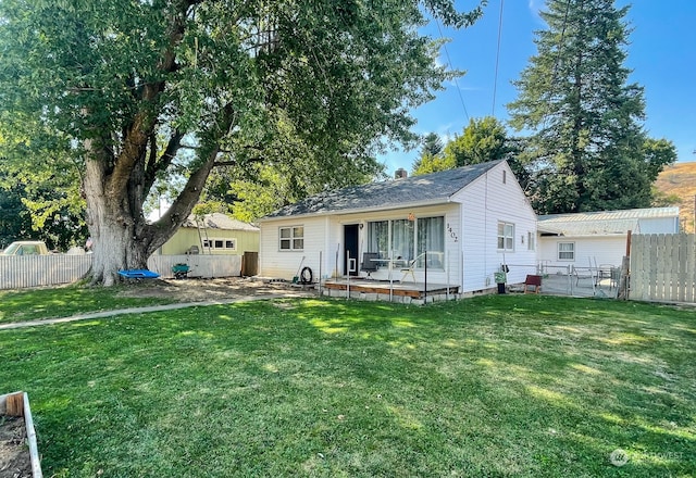 rear view of property featuring a lawn