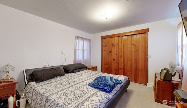 bedroom with a closet and light carpet