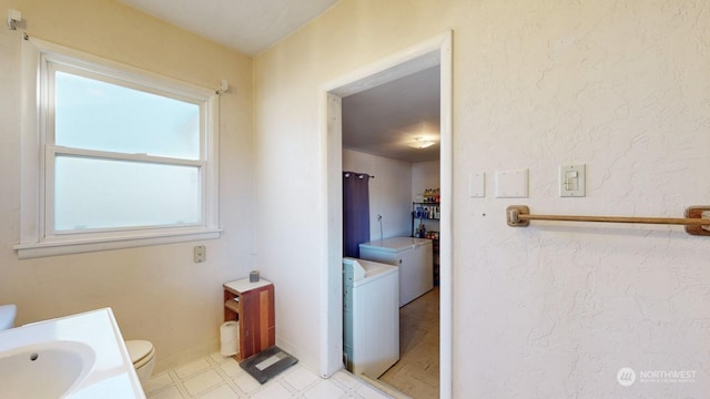 bathroom with toilet, vanity, and washing machine and clothes dryer