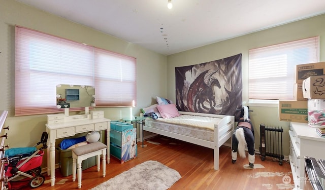 bedroom featuring radiator and light hardwood / wood-style floors