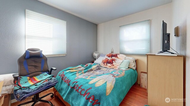 bedroom featuring hardwood / wood-style flooring and multiple windows