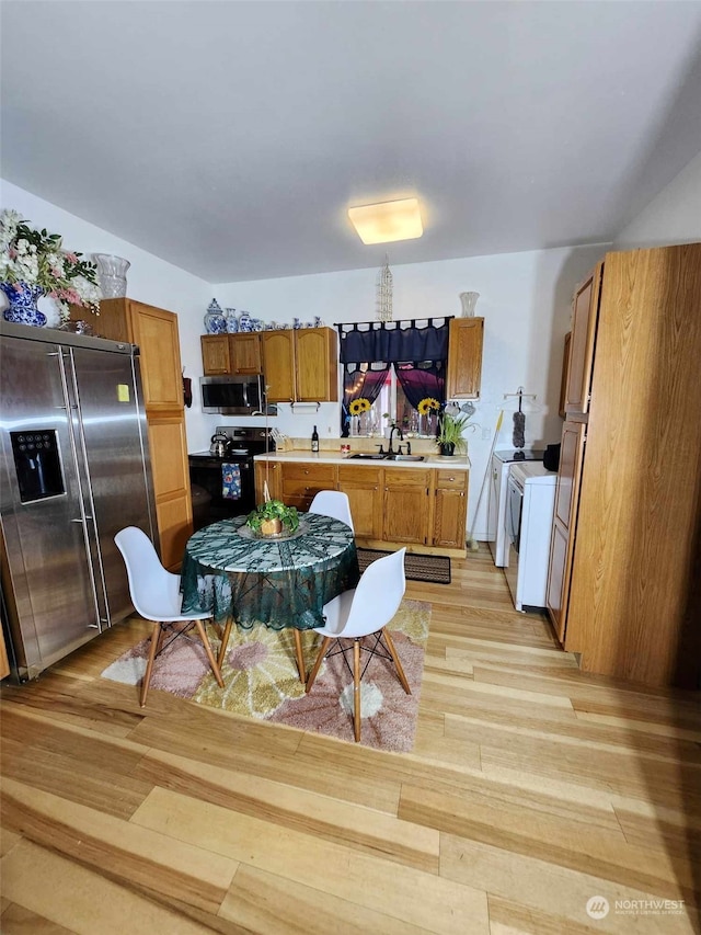 kitchen with sink, stainless steel appliances, and light hardwood / wood-style flooring