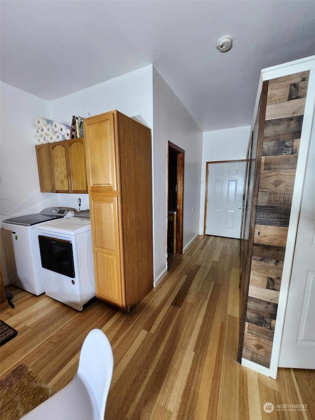 laundry room with cabinets, hardwood / wood-style floors, and washer and clothes dryer