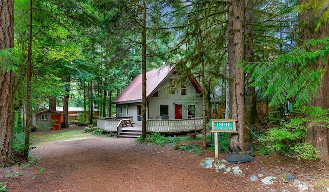 view of front facade featuring a shed and a wooden deck