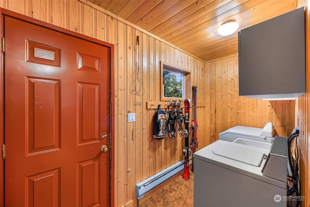 laundry room featuring wood ceiling, wooden walls, baseboard heating, and washer and clothes dryer