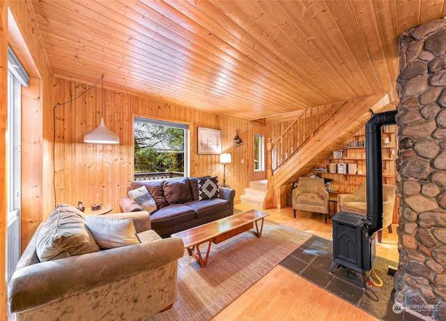 living room featuring wood ceiling, a wood stove, wood walls, lofted ceiling, and hardwood / wood-style floors