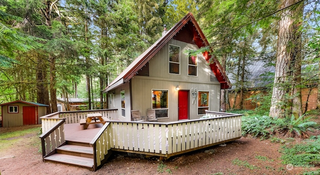 rear view of house featuring a shed and a deck