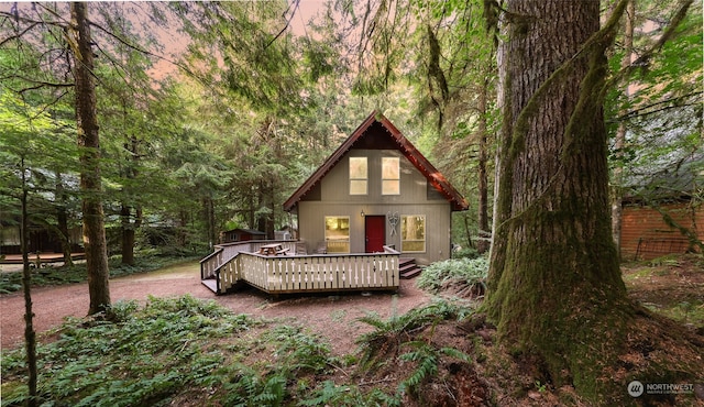 back house at dusk with a wooden deck