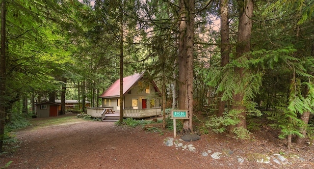 view of front of property with a storage unit and a deck