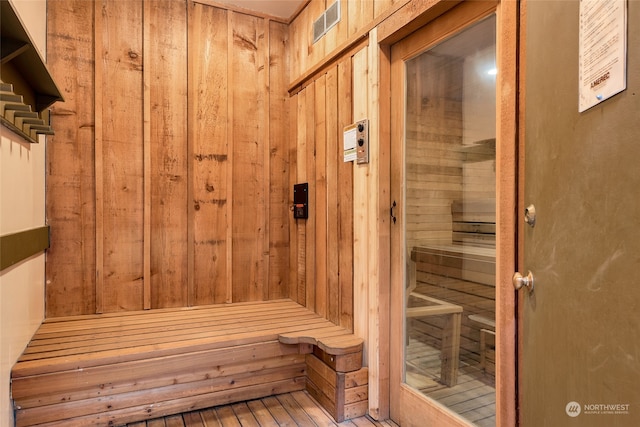 view of sauna / steam room featuring wood-type flooring and wood walls