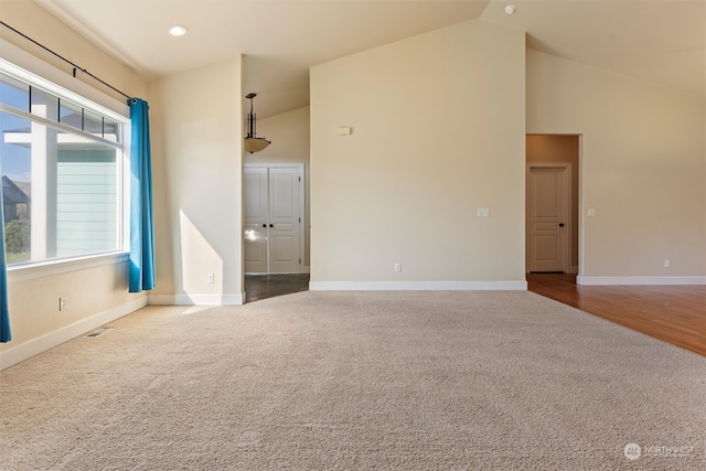 unfurnished room with high vaulted ceiling and carpet