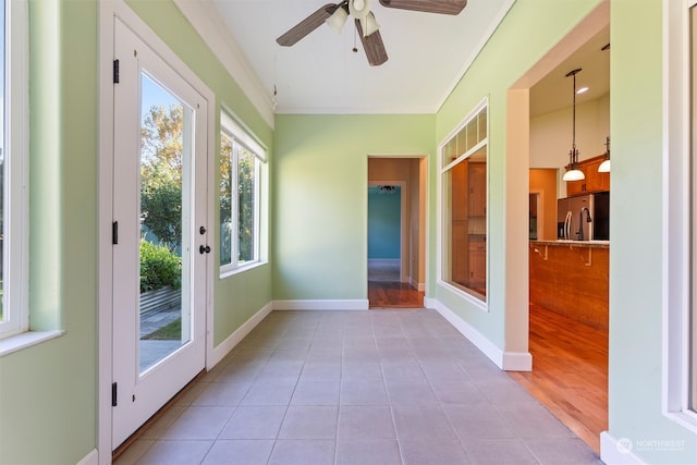 unfurnished sunroom with ceiling fan