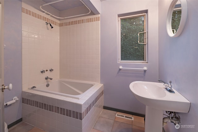 bathroom featuring tiled shower / bath combo and tile patterned flooring