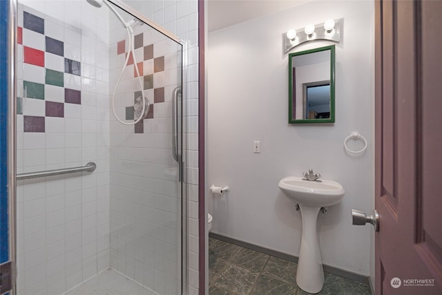 bathroom with toilet and a shower with door