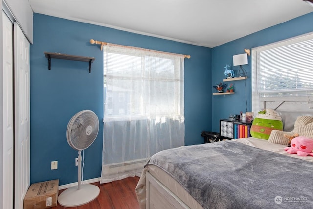 bedroom with dark hardwood / wood-style floors and multiple windows