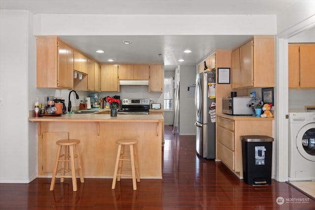 kitchen with washer / clothes dryer, dark wood-type flooring, sink, kitchen peninsula, and appliances with stainless steel finishes