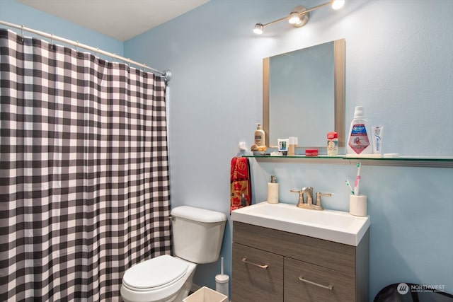 bathroom with a shower with curtain, vanity, and toilet