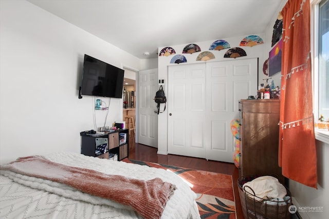 bedroom with a closet and dark wood-type flooring