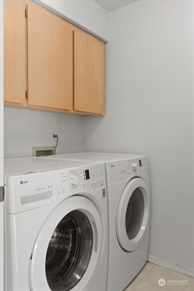 laundry area featuring separate washer and dryer, cabinets, and light tile patterned flooring