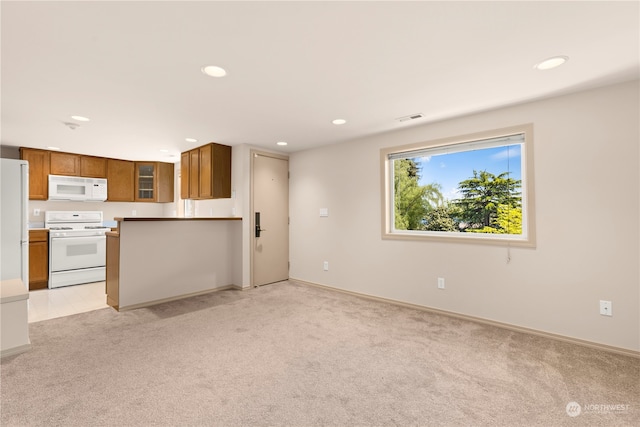 kitchen featuring light carpet and white appliances