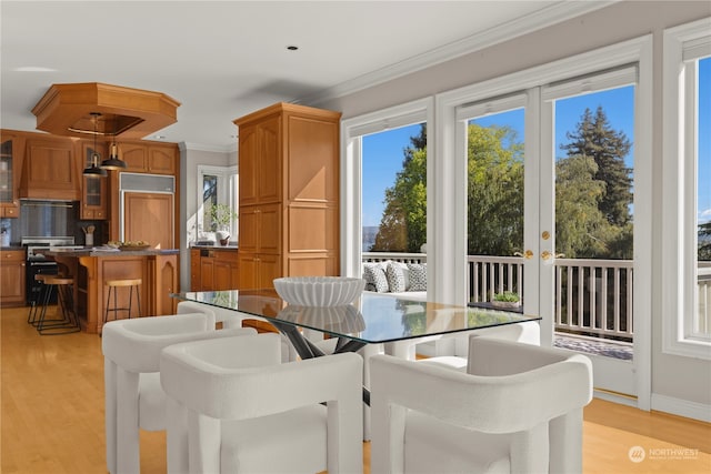 dining area with light wood-type flooring and crown molding