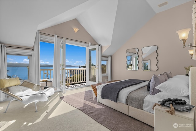 bedroom featuring multiple windows, access to outside, a water view, and vaulted ceiling