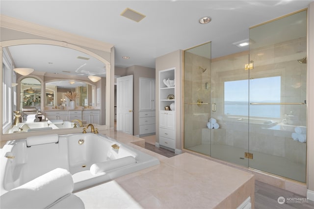 bathroom with a water view, vanity, and separate shower and tub