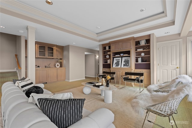 living room with crown molding, a tray ceiling, and sink