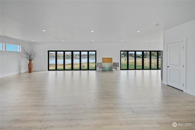 spare room with plenty of natural light and light hardwood / wood-style flooring