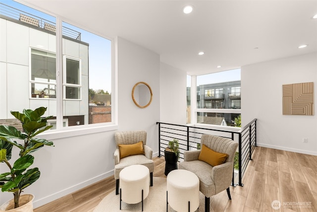 living area featuring baseboards, light wood-style floors, and recessed lighting