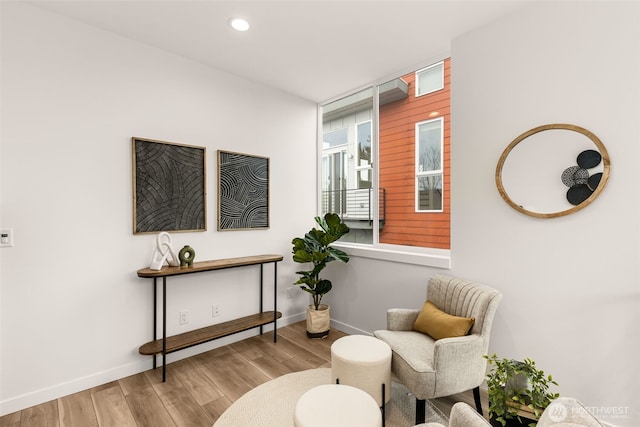 living area with recessed lighting, baseboards, and wood finished floors