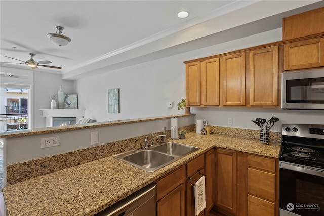 kitchen with ceiling fan, stainless steel appliances, sink, and kitchen peninsula