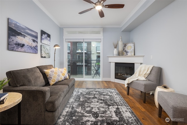 living room with ornamental molding, dark hardwood / wood-style floors, and ceiling fan