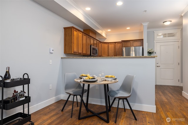 dining space with ornamental molding and dark hardwood / wood-style floors