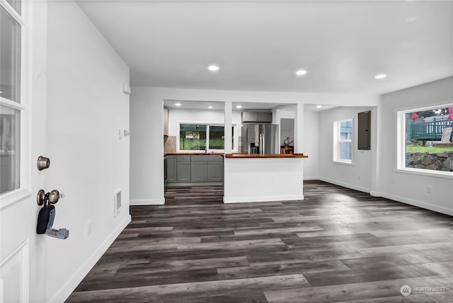 kitchen with gray cabinetry, dark hardwood / wood-style floors, stainless steel fridge with ice dispenser, and a wealth of natural light