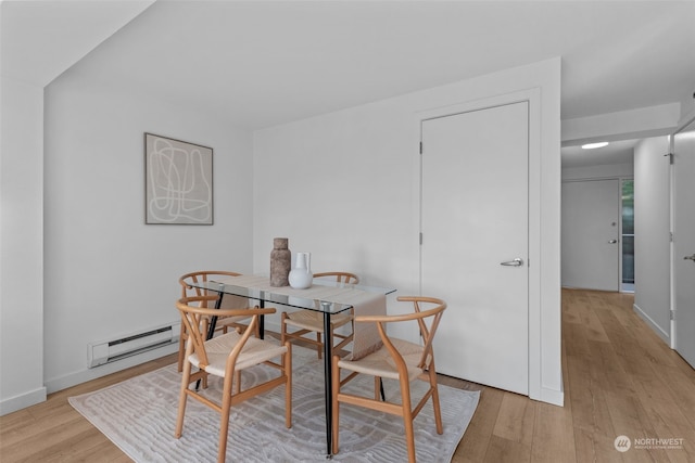 dining room with a baseboard heating unit and light hardwood / wood-style floors