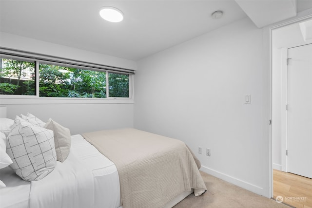 bedroom with wood-type flooring and multiple windows