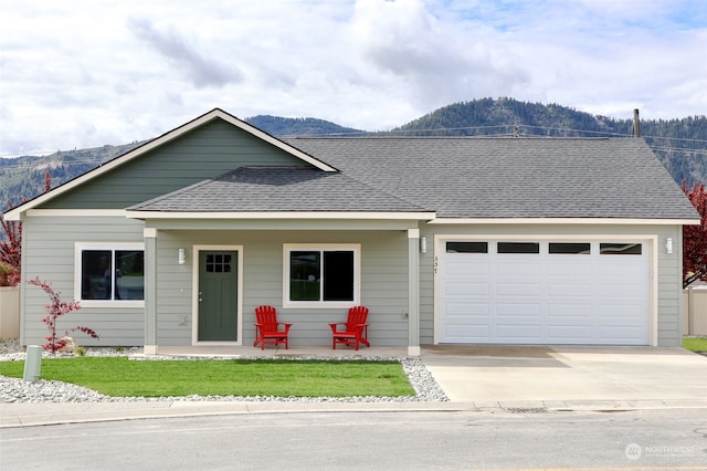 single story home featuring a garage, a mountain view, and covered porch