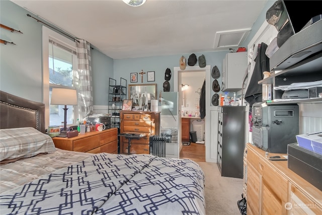 bedroom with light carpet and ensuite bathroom