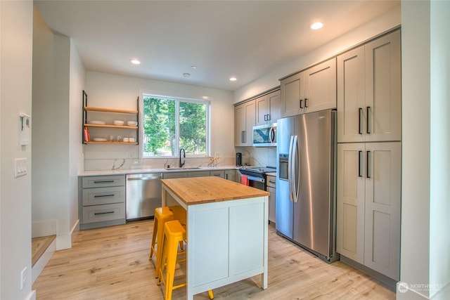 kitchen featuring wood counters, sink, a kitchen bar, a center island, and stainless steel appliances