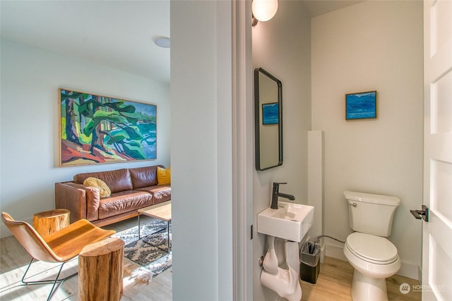 bathroom featuring wood-type flooring and toilet