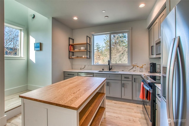 kitchen featuring sink, plenty of natural light, stainless steel appliances, and a kitchen island