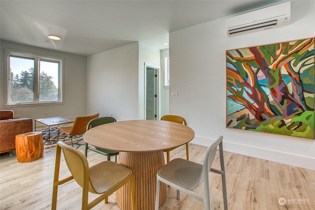 dining space featuring a wall unit AC and light hardwood / wood-style floors