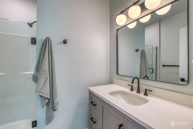 bathroom with vanity and a shower with door